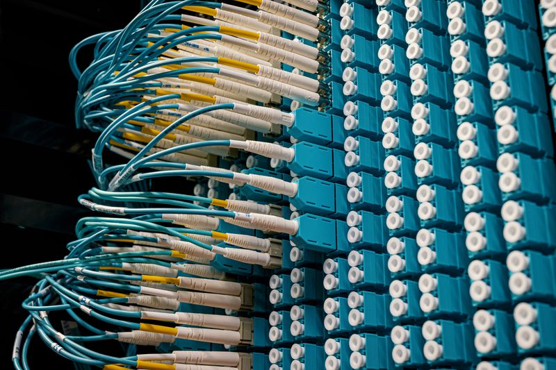 Cabos de rede organizados e conectados a um painel de distribuição em rack